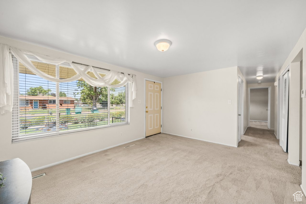 Empty room with light carpet and baseboards