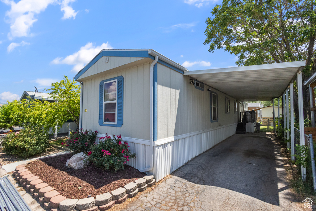 View of front of house with asphalt driveway and a carport