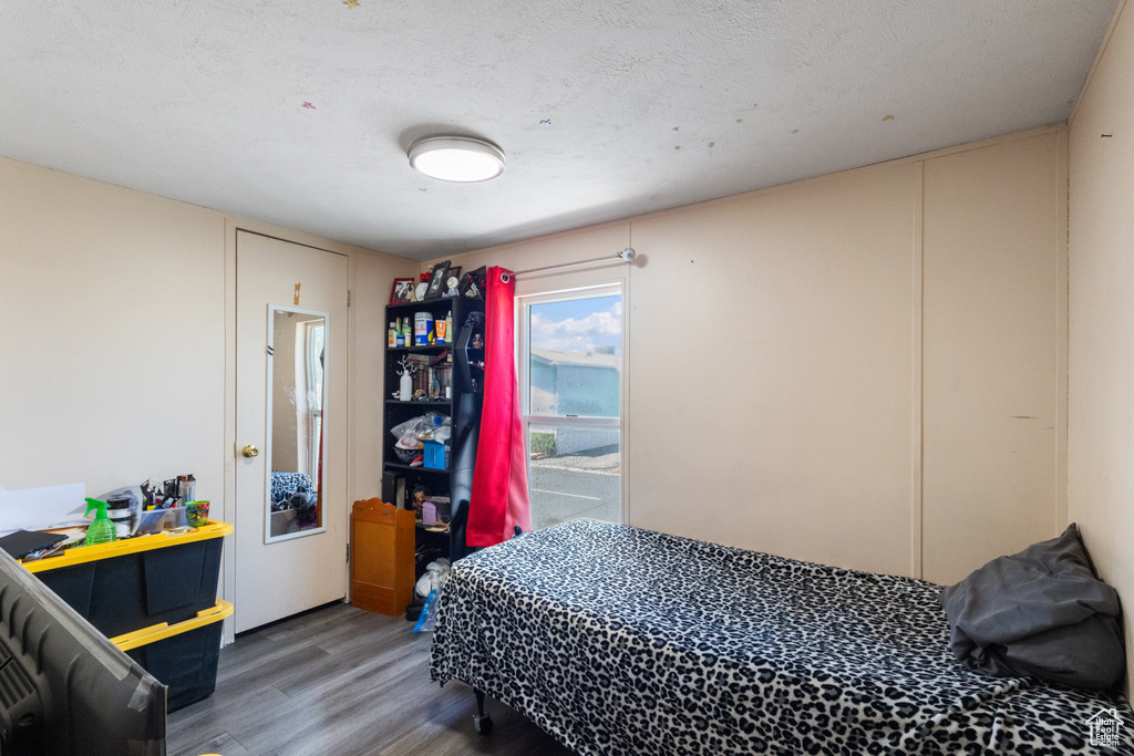 Bedroom with wood finished floors and a textured ceiling