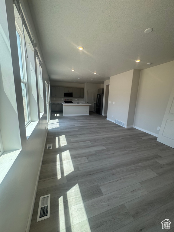 Unfurnished living room with recessed lighting, a textured ceiling, and light wood finished floors