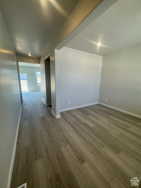 Unfurnished room featuring dark wood-style floors and a textured ceiling