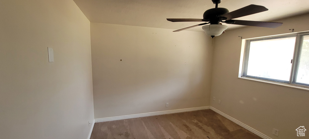 Carpeted spare room with ceiling fan and healthy amount of natural light