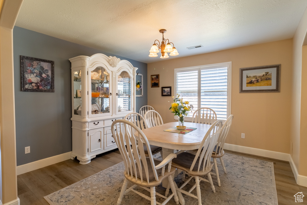 Dining area featuring a chandelier and wood finished floors