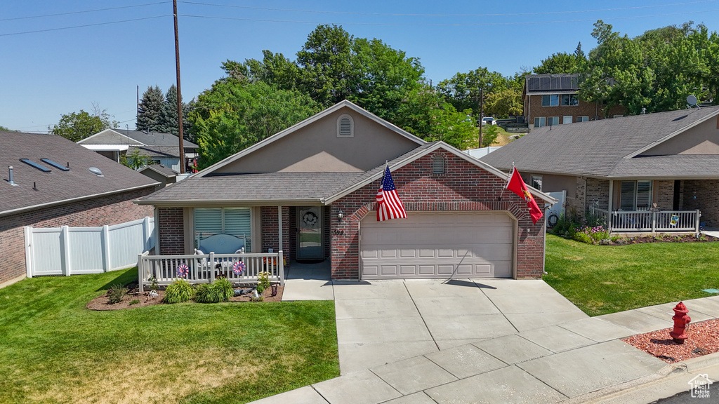 View of front facade featuring covered porch, brick siding, an attached garage, and driveway