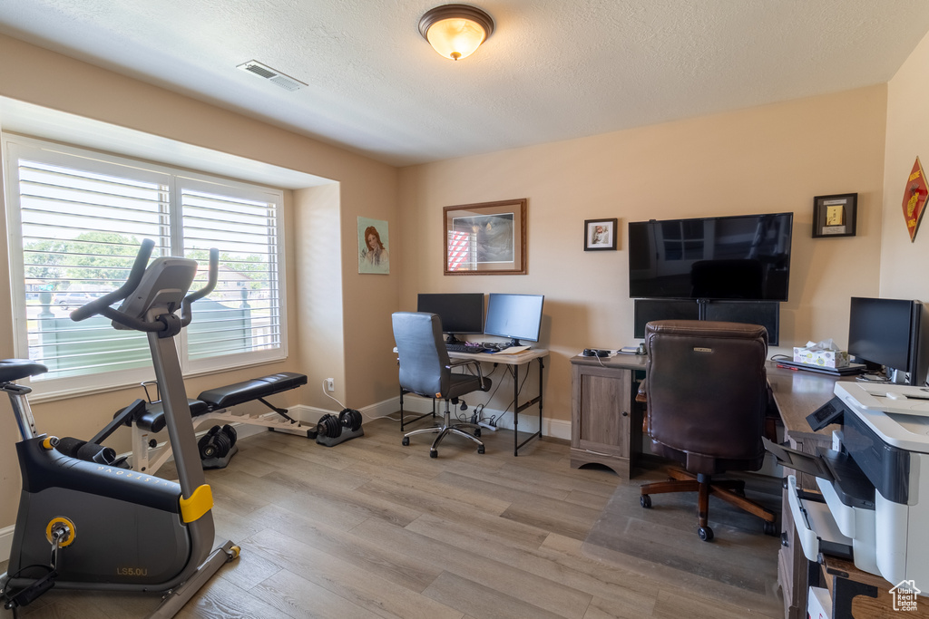 Office with wood finished floors and a textured ceiling
