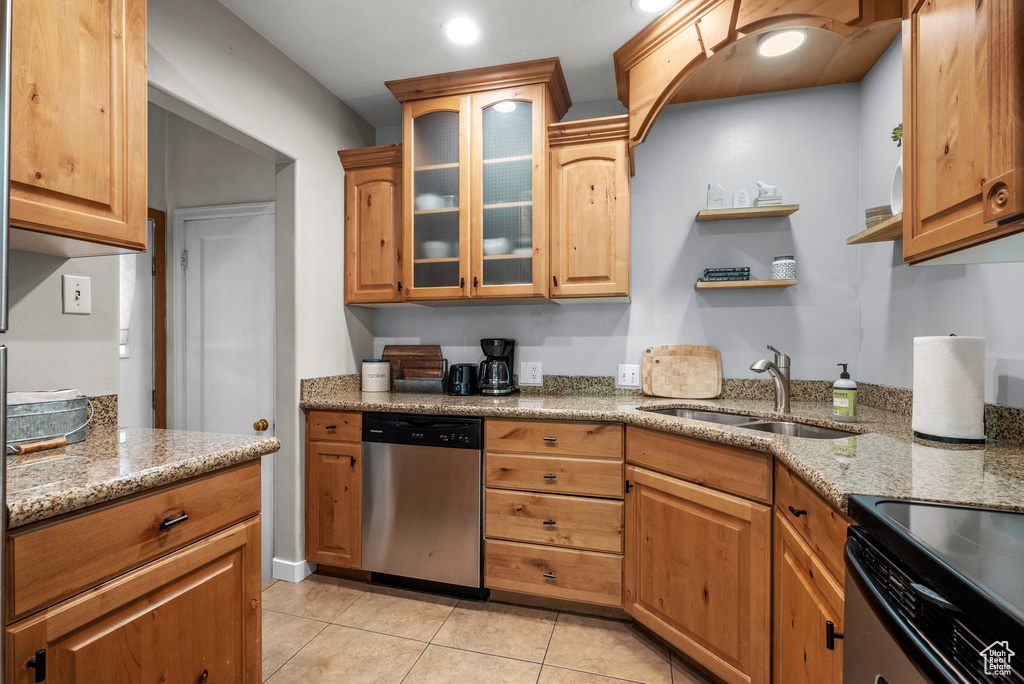 Kitchen with stainless steel dishwasher, light tile patterned flooring, light stone countertops, glass insert cabinets, and recessed lighting