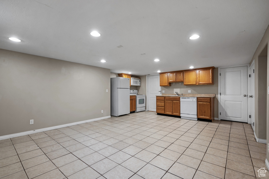 Kitchen with white appliances, recessed lighting, light countertops, and brown cabinetry