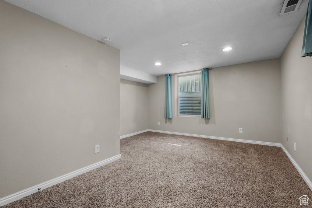 Carpeted empty room with baseboards and recessed lighting
