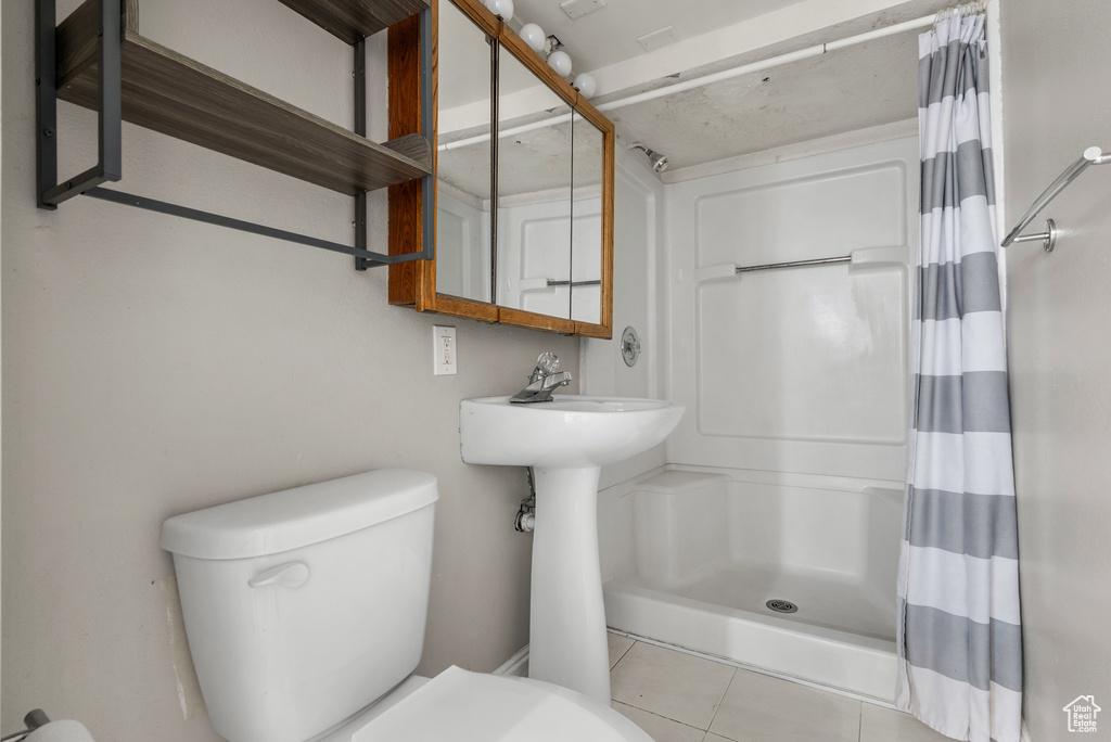 Full bathroom featuring a shower with curtain and tile patterned flooring