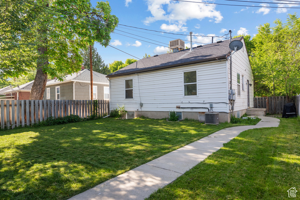 View of property exterior featuring a central AC unit and roof with shingles