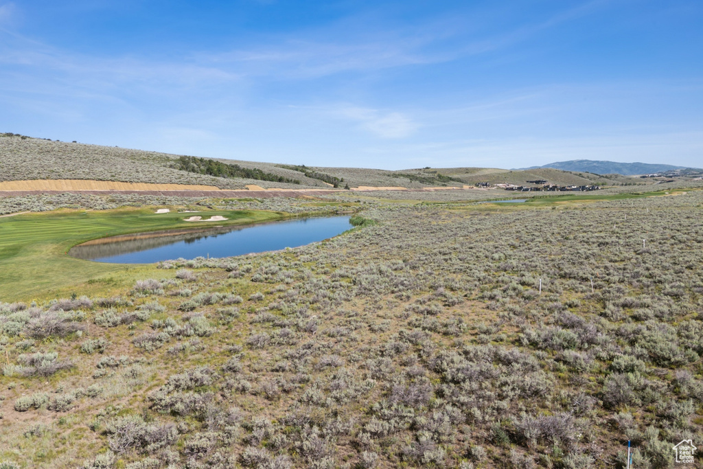 Water view featuring a mountainous background and a local golf course
