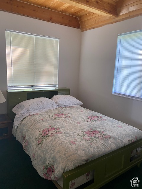 Bedroom featuring a wooden ceiling with exposed beams