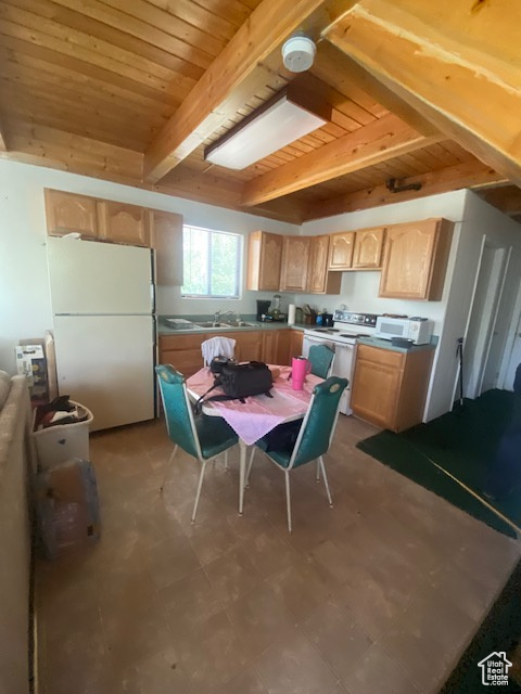 Kitchen featuring white appliances, light brown cabinets, a wood ceiling with exposed beams, and tile patterned floors