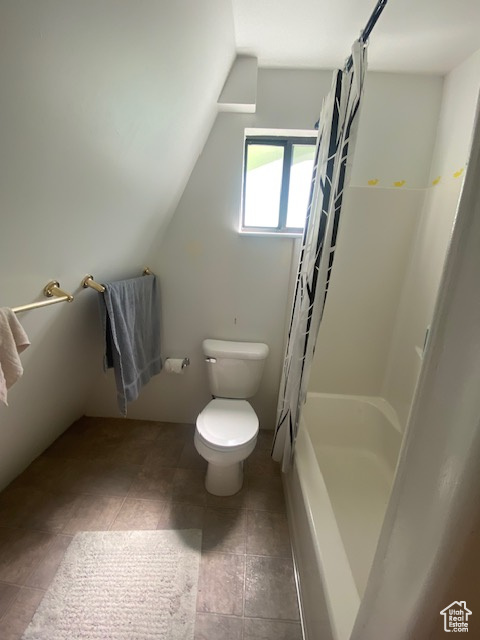 Bathroom with lofted ceiling, tile patterned flooring, and shower / bath combo