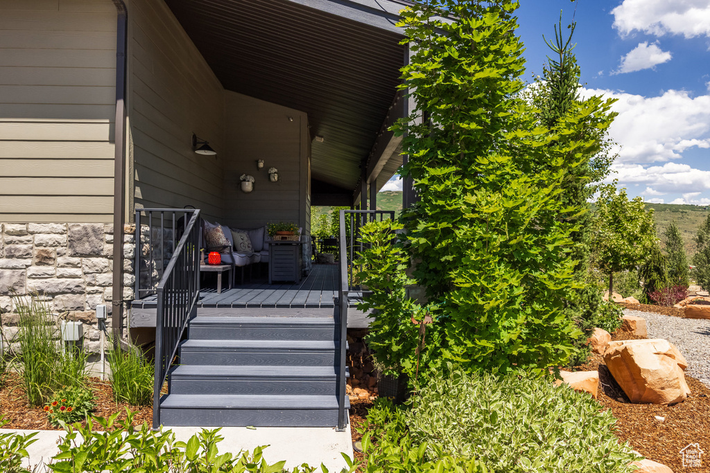 Property entrance featuring stone siding and a wooden deck