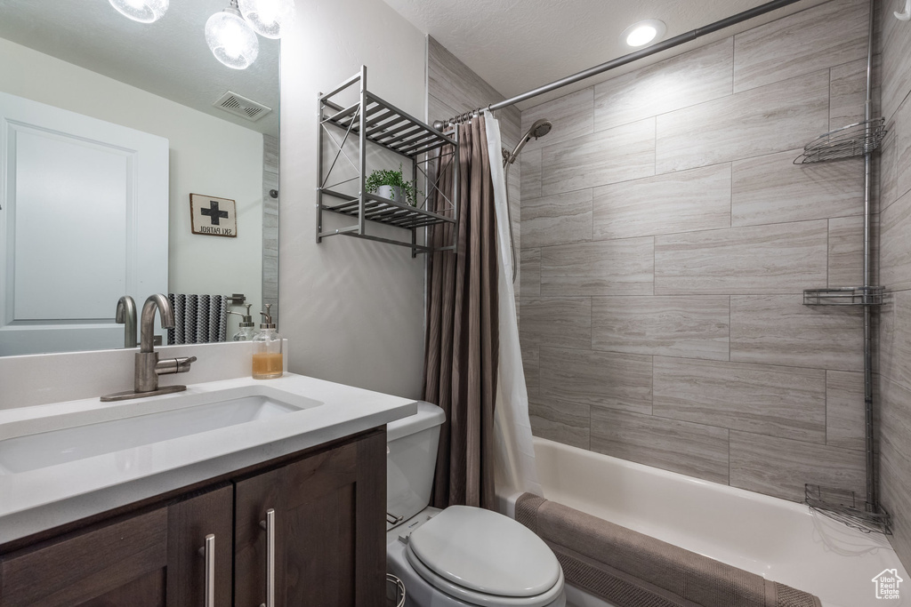 Full bathroom with shower / bath combo with shower curtain and vanity