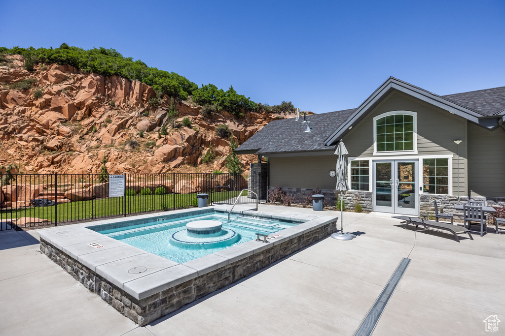 View of swimming pool featuring an in-ground hot tub, french doors, and a patio