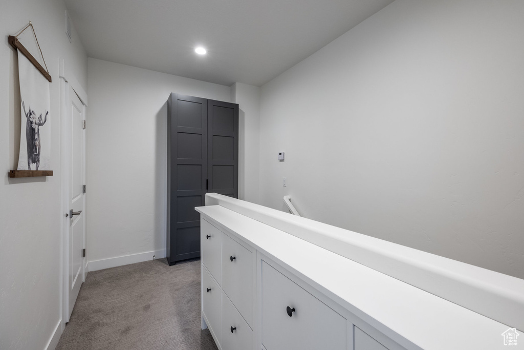 Hallway featuring light carpet and recessed lighting