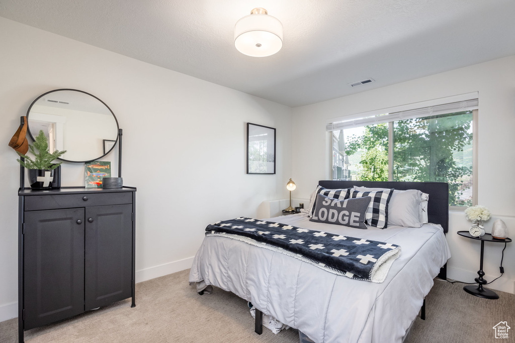 Bedroom featuring light colored carpet and baseboards
