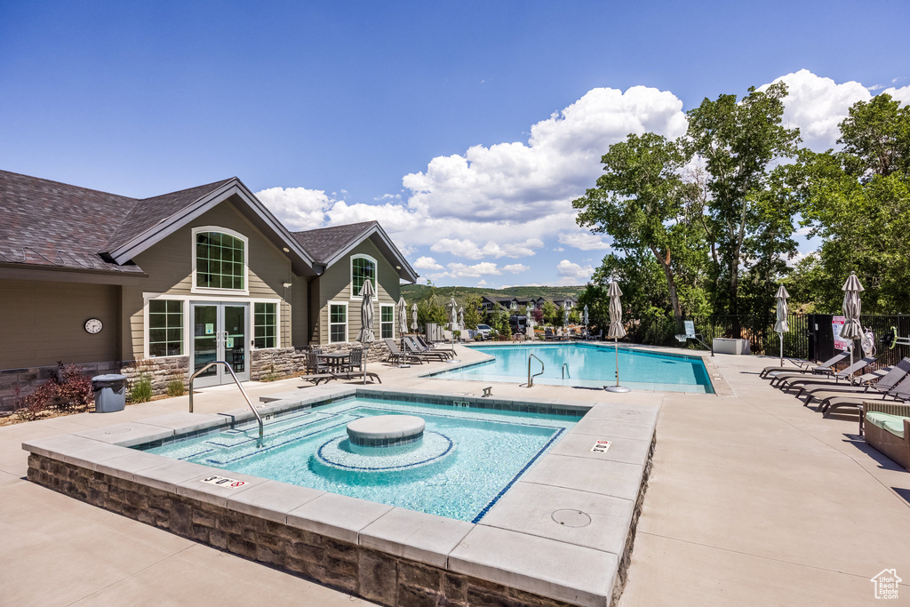 Community pool featuring french doors and a patio area