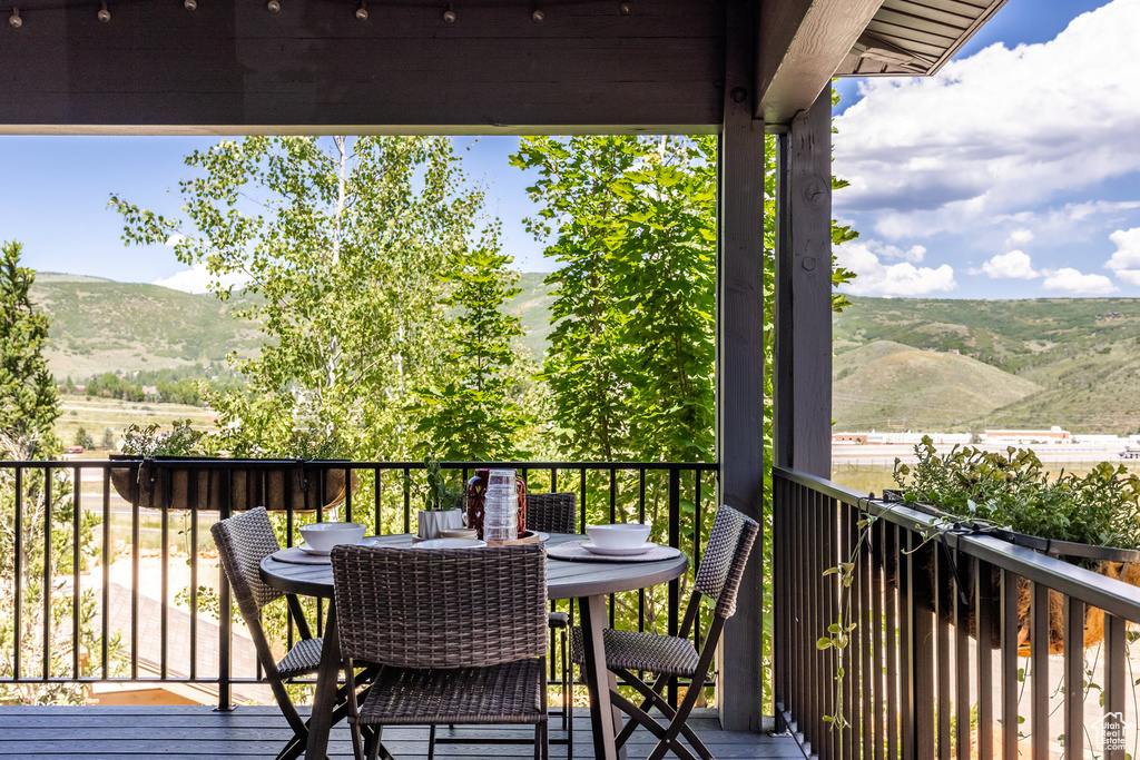 Wooden terrace featuring a mountain view and outdoor dining space