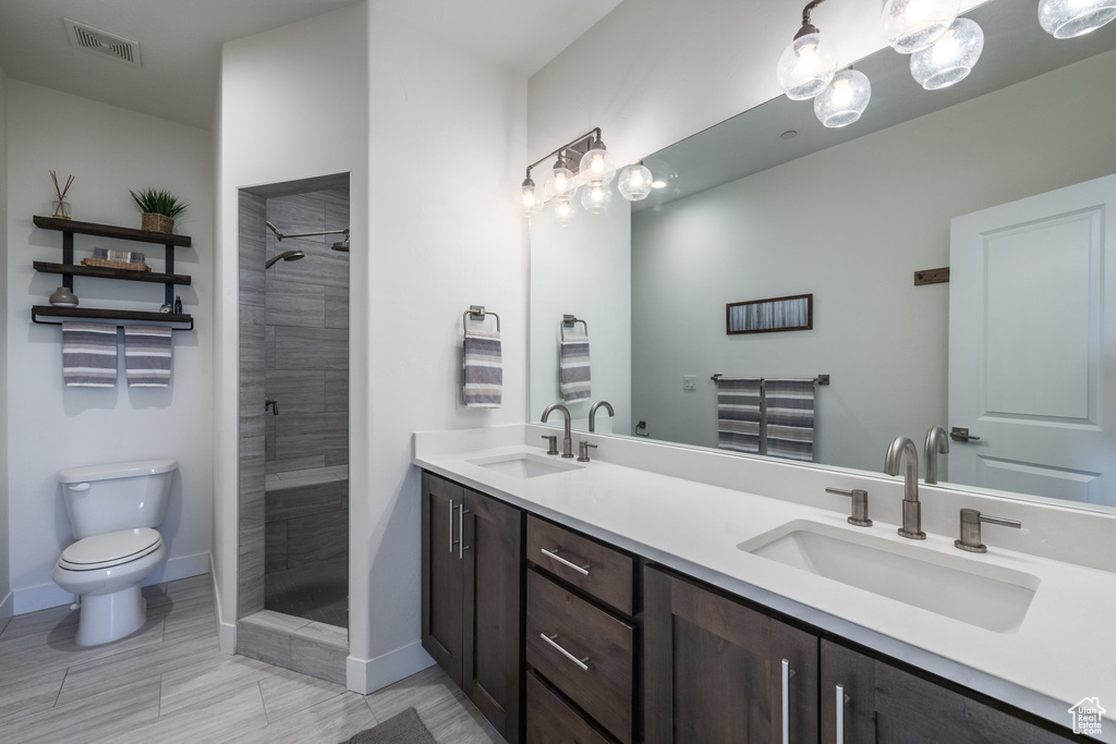 Full bathroom with double vanity and tiled shower