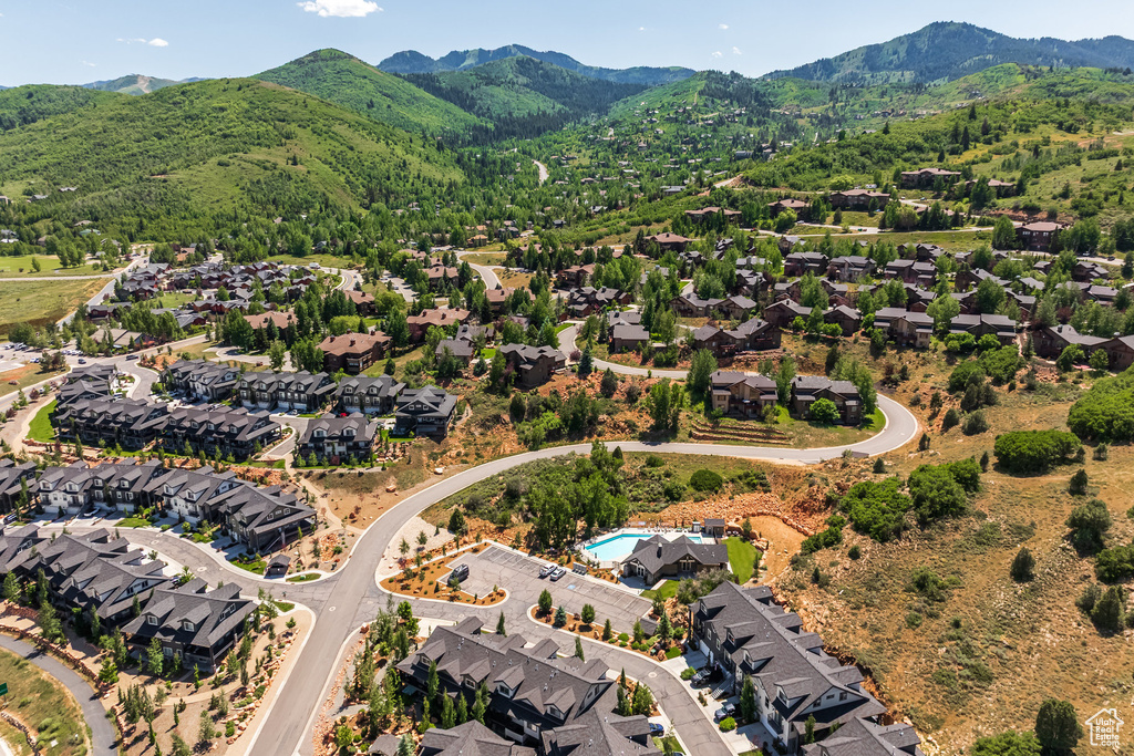 Aerial perspective of suburban area featuring a mountain backdrop and a pool area