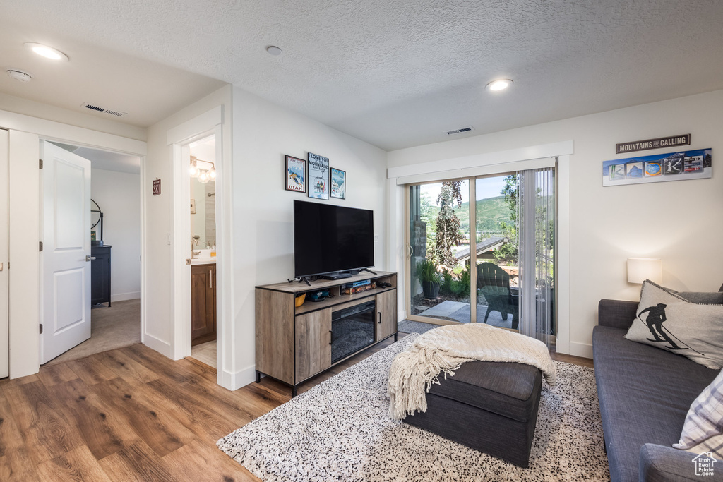 Living room featuring wood finished floors, recessed lighting, and a textured ceiling