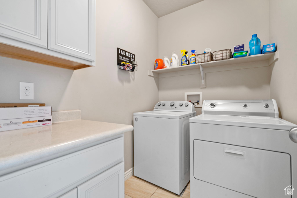 Washroom featuring separate washer and dryer and cabinet space