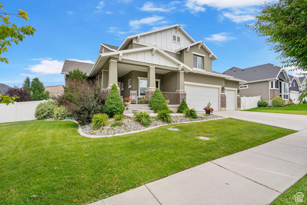 Craftsman house with a porch, board and batten siding, driveway, and stucco siding