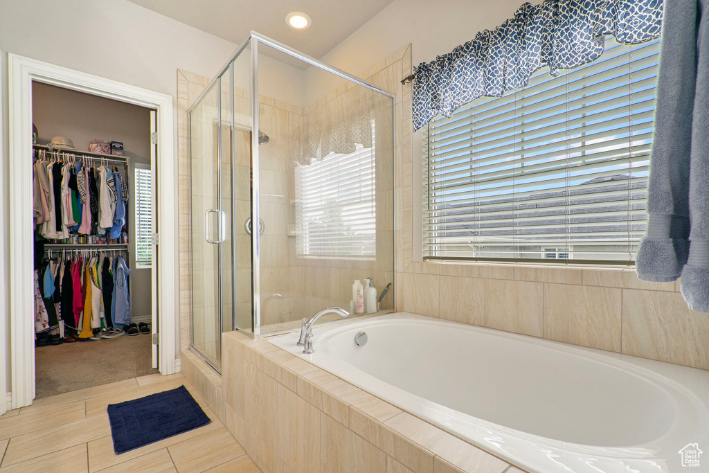 Full bath featuring a bath, a shower stall, and a spacious closet
