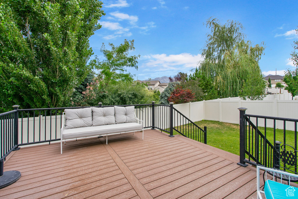 Wooden deck with a fenced backyard and outdoor lounge area