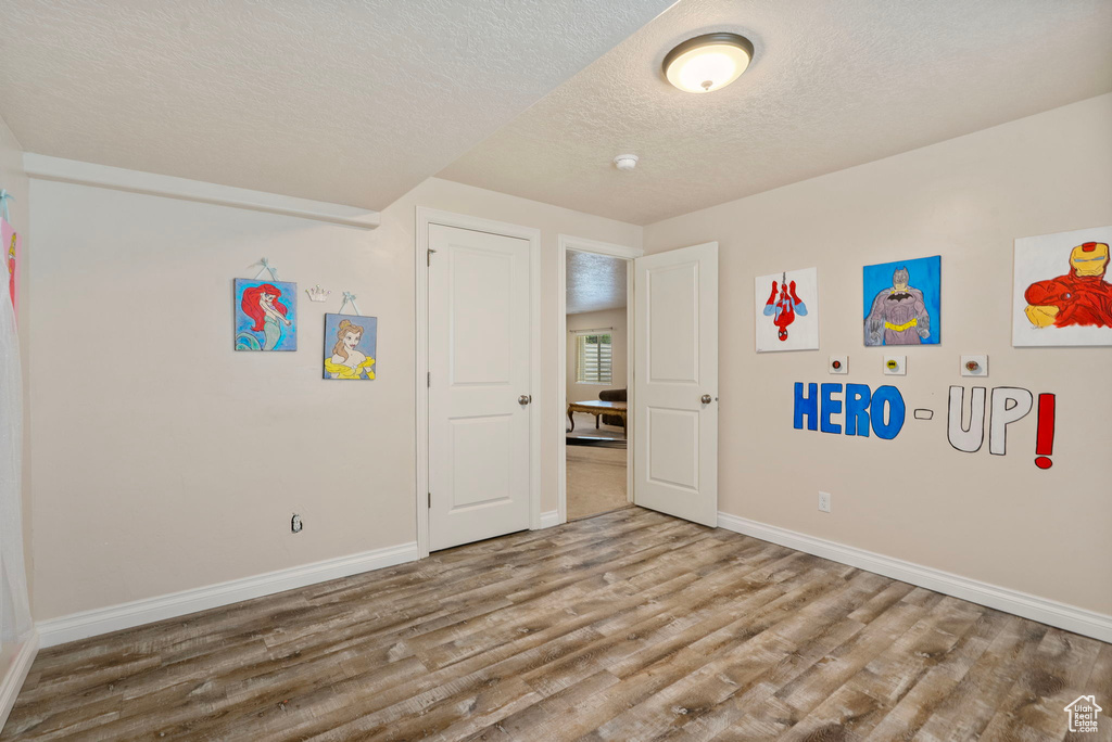 Unfurnished bedroom featuring wood finished floors and a textured ceiling