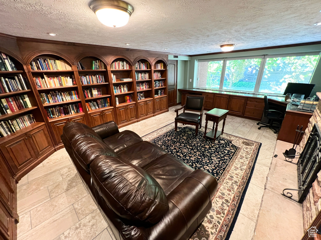 Office area with a textured ceiling, built in shelves, and bookshelves