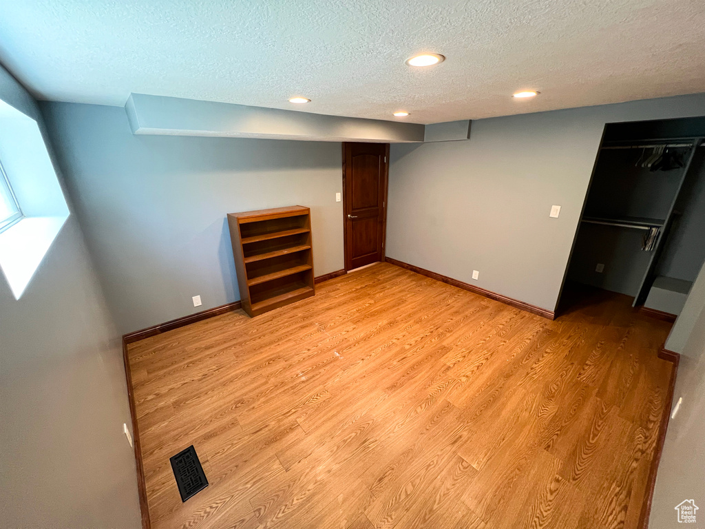 Unfurnished bedroom with a textured ceiling, light wood-style floors, and recessed lighting