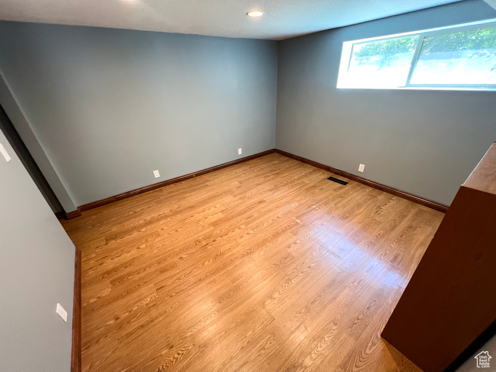 Empty room with light wood-style flooring and recessed lighting
