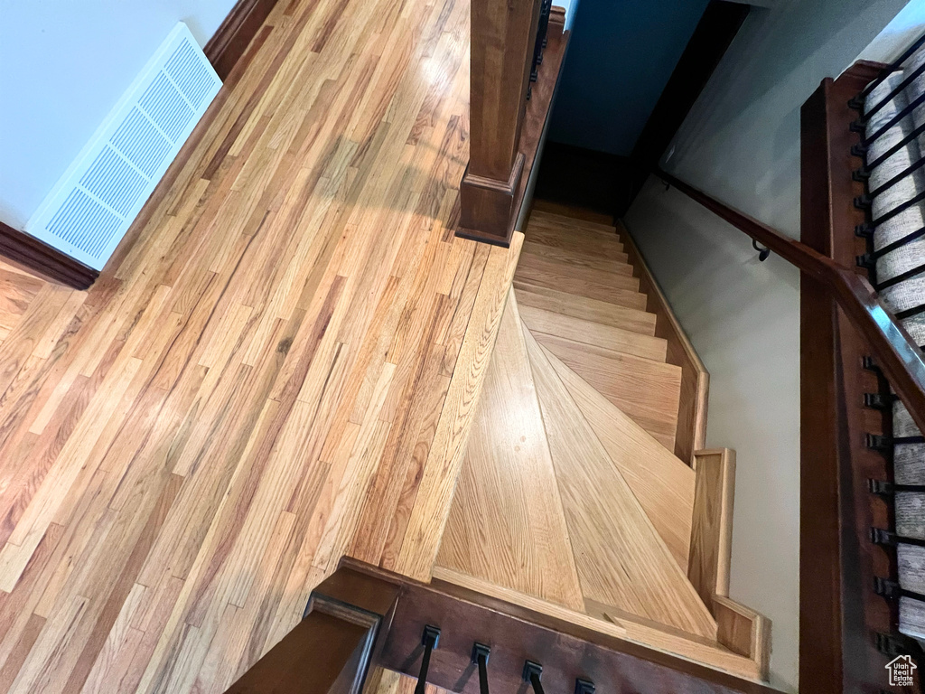 Stairway featuring wood finished floors