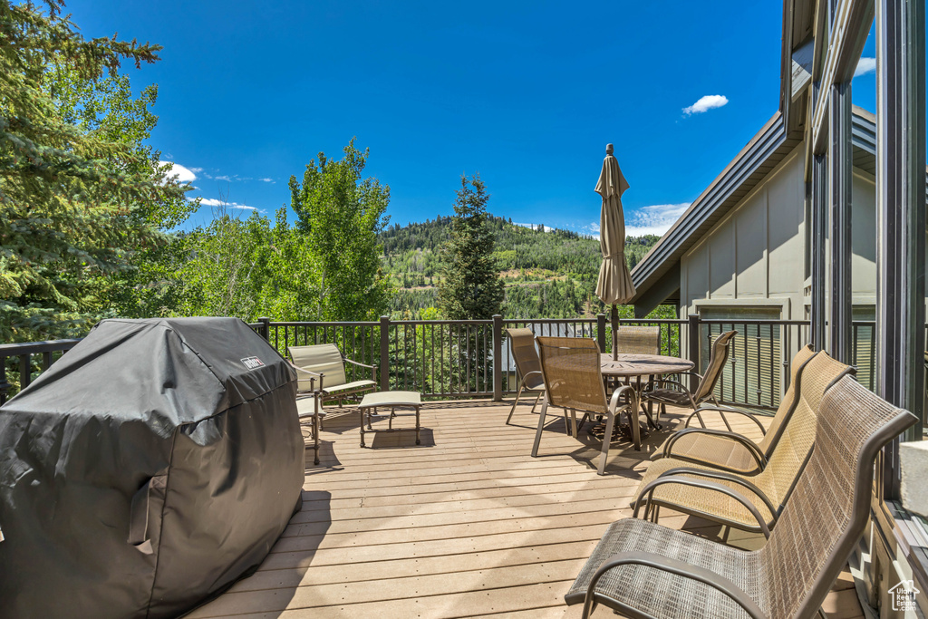 Wooden deck featuring grilling area and outdoor dining space