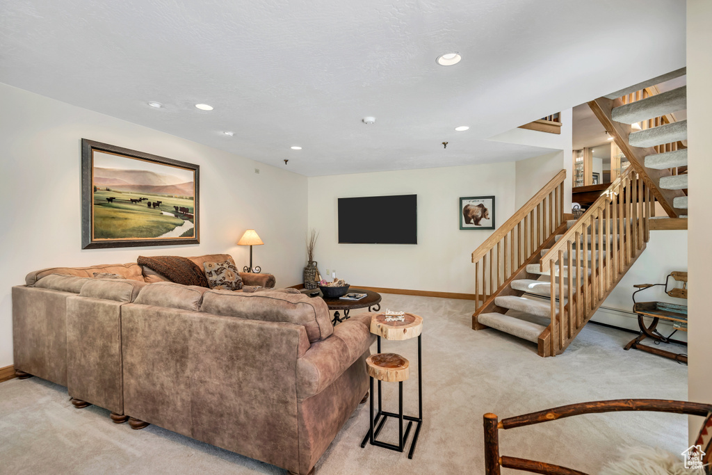Living room with light carpet, stairway, and recessed lighting