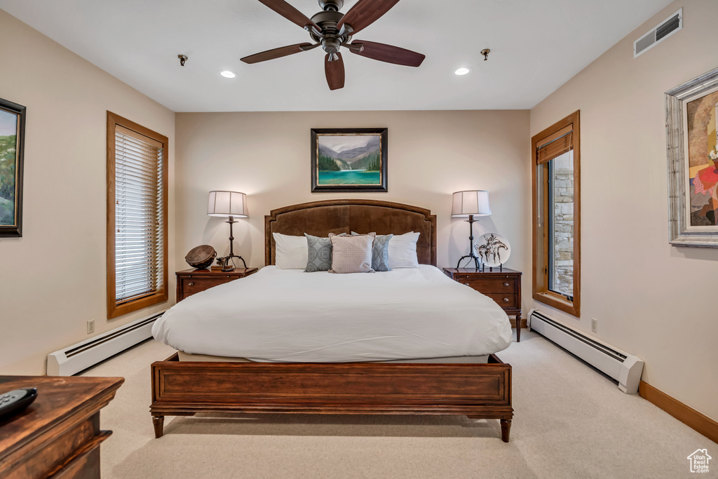 Bedroom featuring baseboard heating, light carpet, recessed lighting, and a ceiling fan