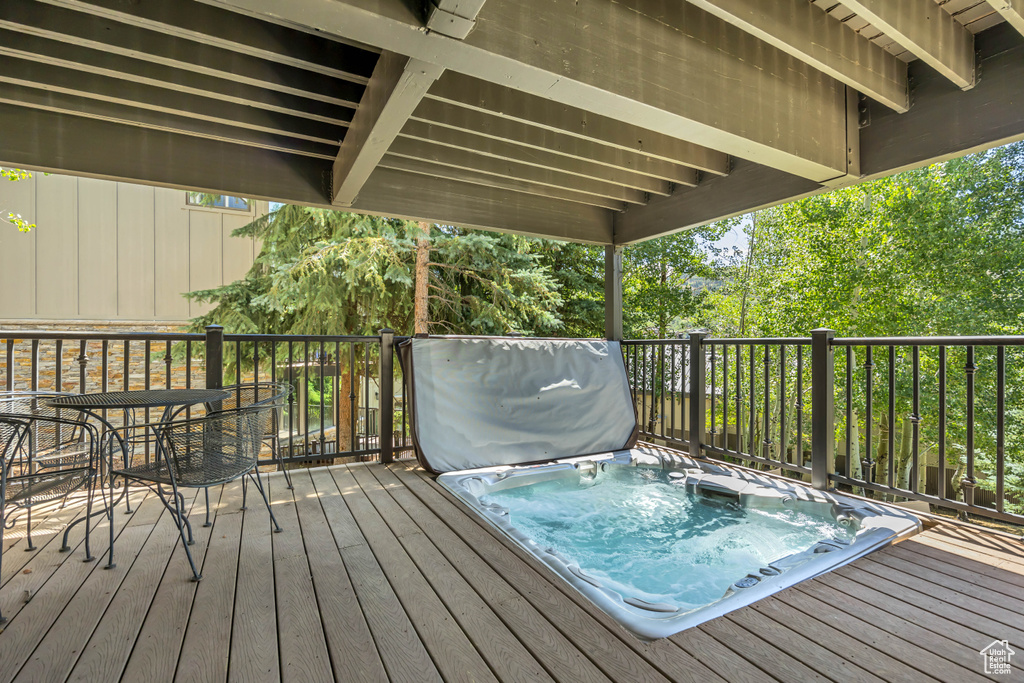 Wooden terrace with a covered hot tub and outdoor dining space