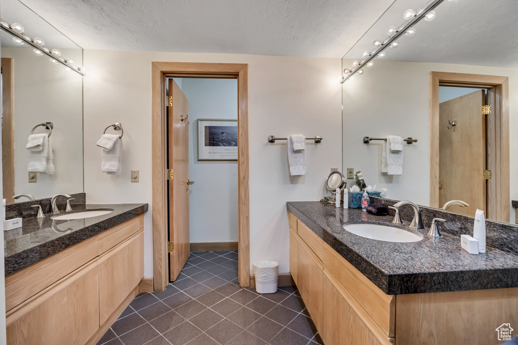 Full bathroom featuring two vanities and tile patterned flooring