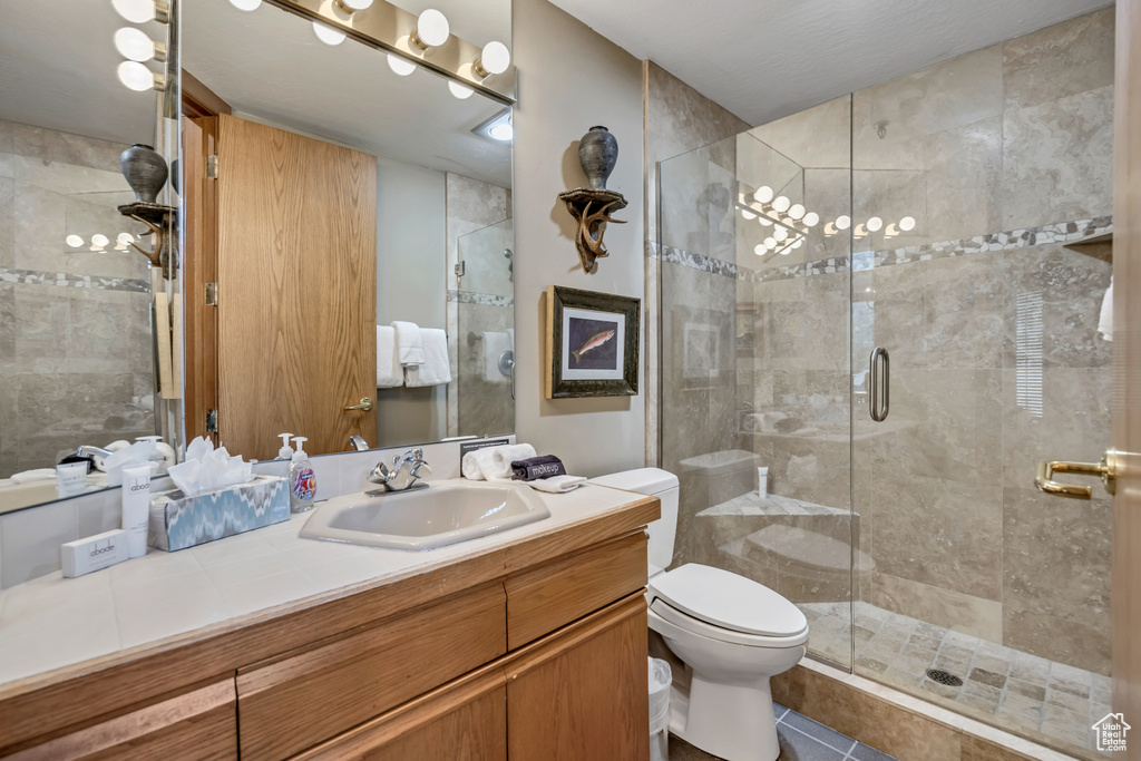 Full bath with vanity, a stall shower, and tile patterned floors