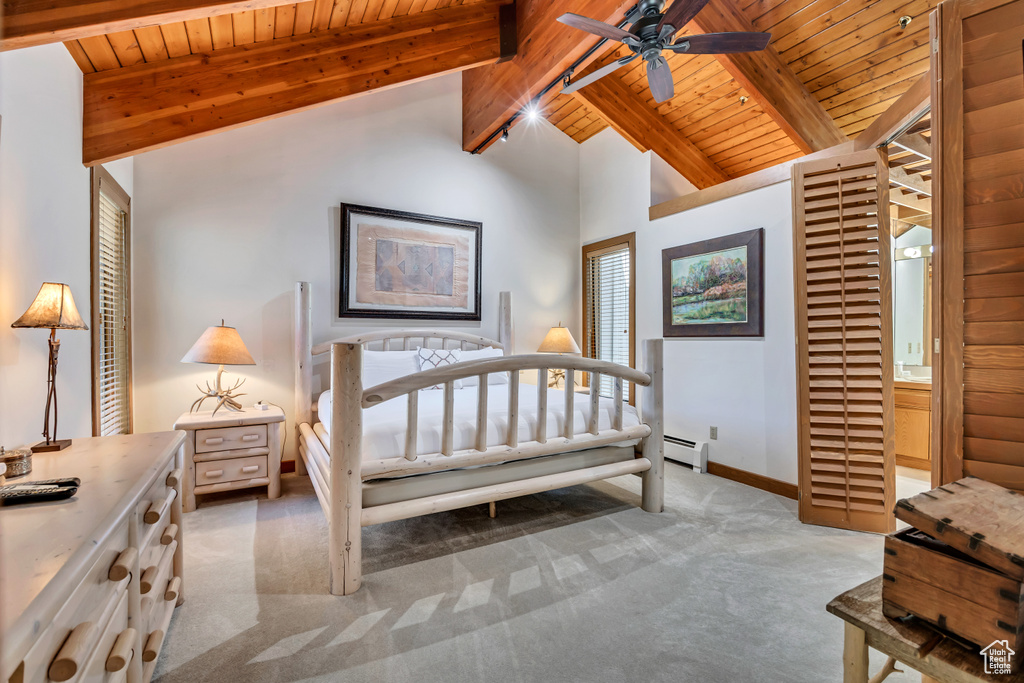 Bedroom with light colored carpet, wood ceiling, and baseboard heating