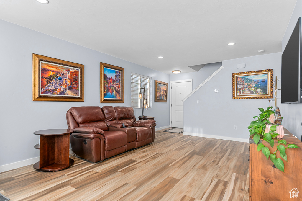 Living room with light wood-type flooring and recessed lighting