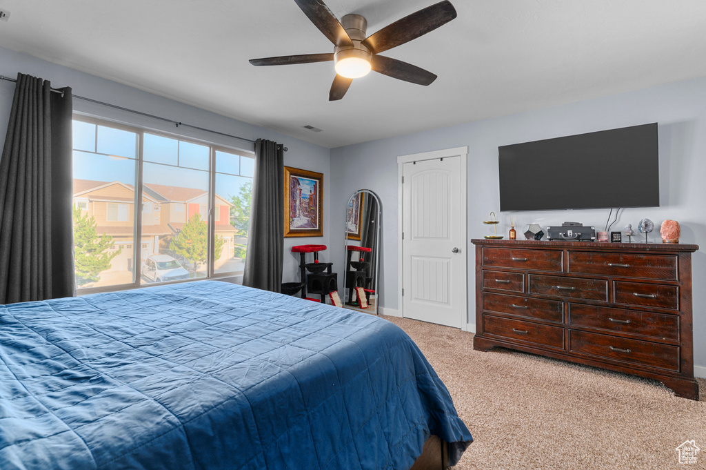 Bedroom with light colored carpet and a ceiling fan