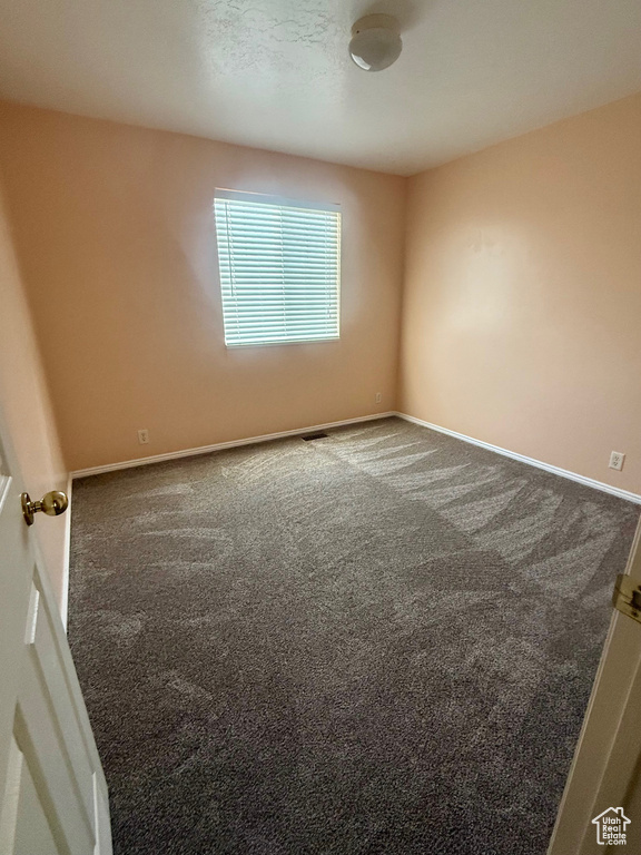 Carpeted spare room with baseboards