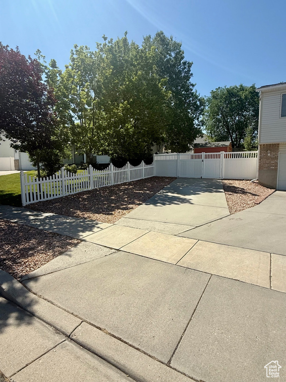 View of patio / terrace with driveway, a gate, and a fenced front yard