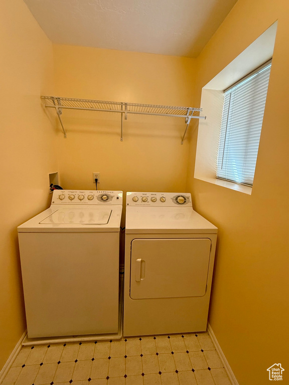 Laundry room with washing machine and clothes dryer and light flooring