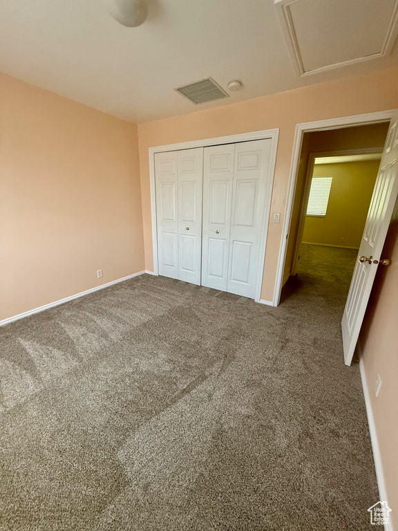 Unfurnished bedroom with carpet and a closet